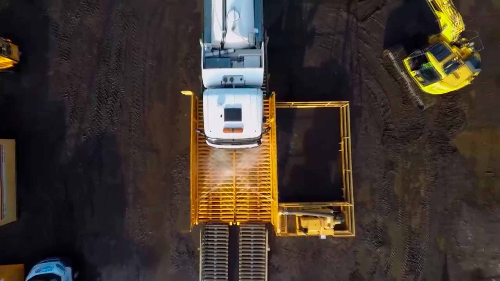 camion pasando sobre un sistema de lavado de llantas en una zona de construccion - ver detalles